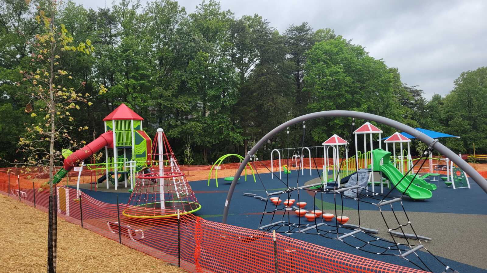 The playground at Reston North is shown in this image. There are green slides, climbing ropes, and other equipment.