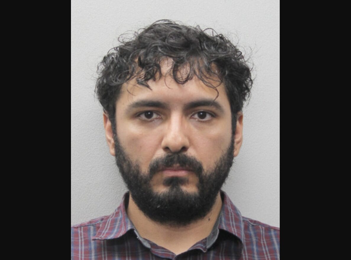 Eliseo Perez (courtesy Fairfax County Police Department) | FFXnow Front-facing mugshot of a man with dark hair and beard wearing a red plaid shirt against a gray wall