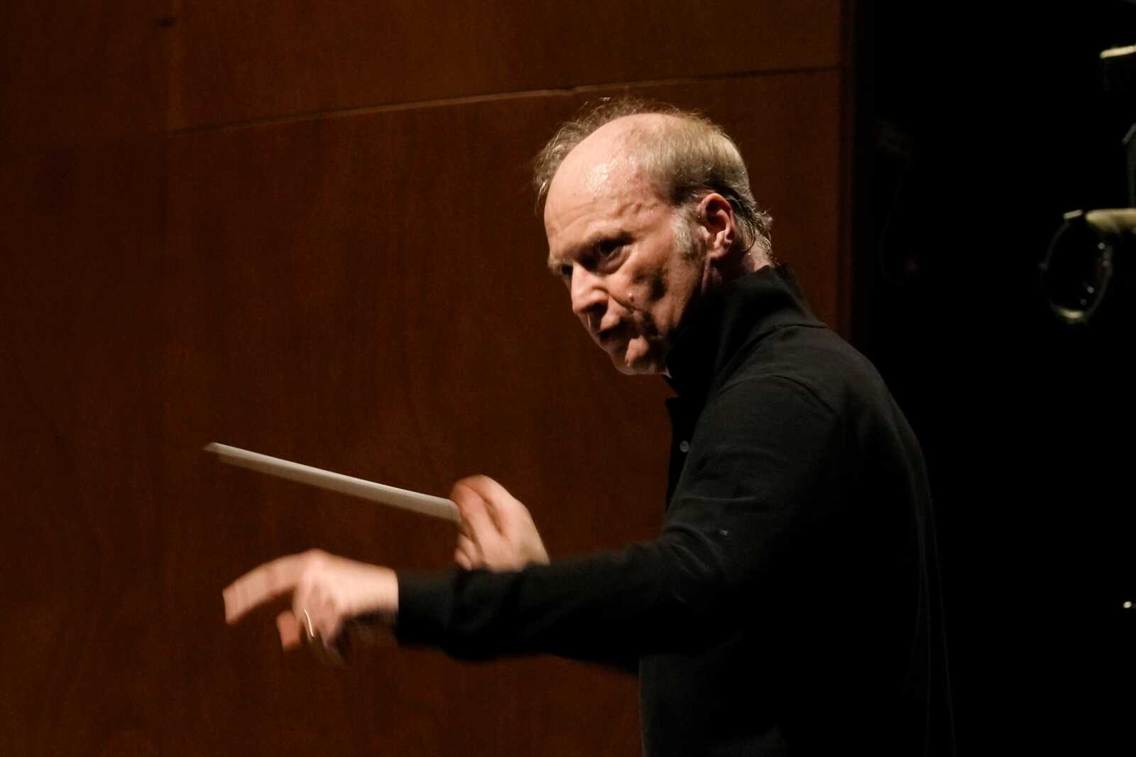 FILE - Music Director of the National Symphony Orchestra (NSO) Gianandrea Noseda conducts the orchestra during a rehearsal at Milan's La Scala theatre, Italy, on Feb. 26, 2024. (AP Photo/Antonio Calanni, File) | FFXnow Male conductor in a black shirt directing with a baton on stage.