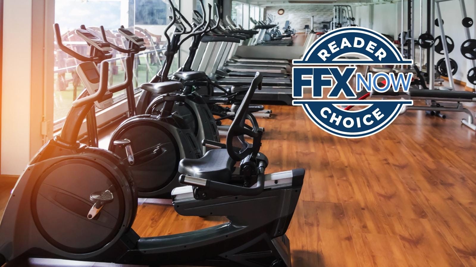 Gym interior with treadmills and stationary bikes; a large blue circular badge on the right reads 'READERS NOW FFX CHOICE'