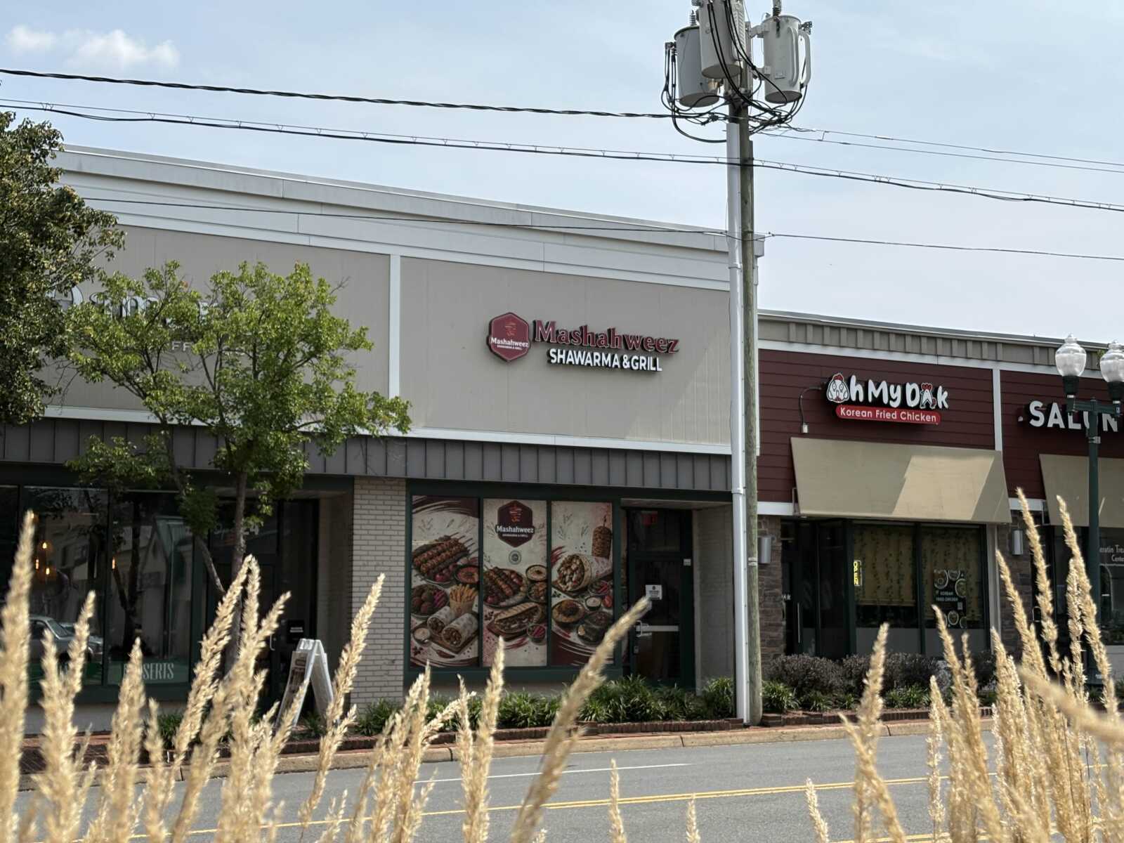 Shawarma & Grill restaurant sign in a shopping plaza with a neighboring Korean fried chicken restaurant next door.