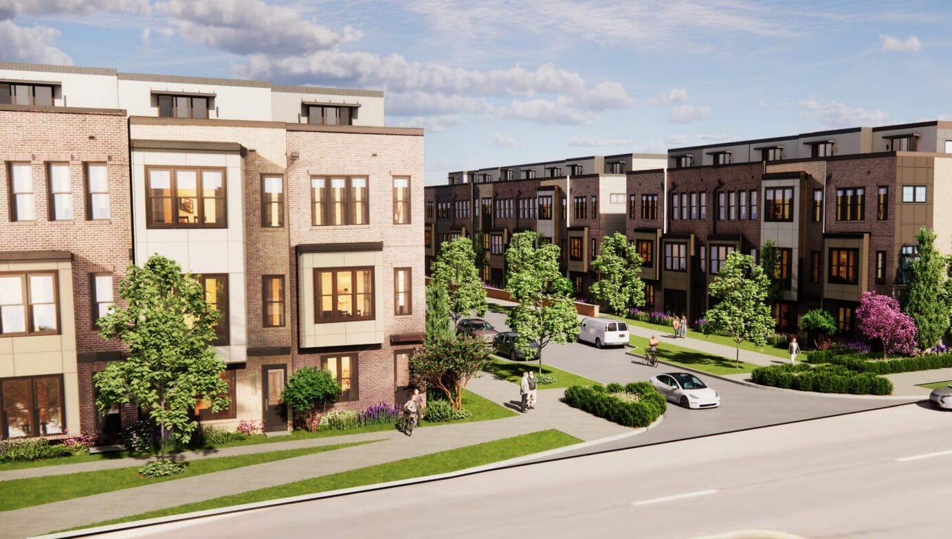Row of modern brick townhouses with green lawns, trees, and a curved street with parked cars and pedestrians, in a sunny neighborhood setting.
