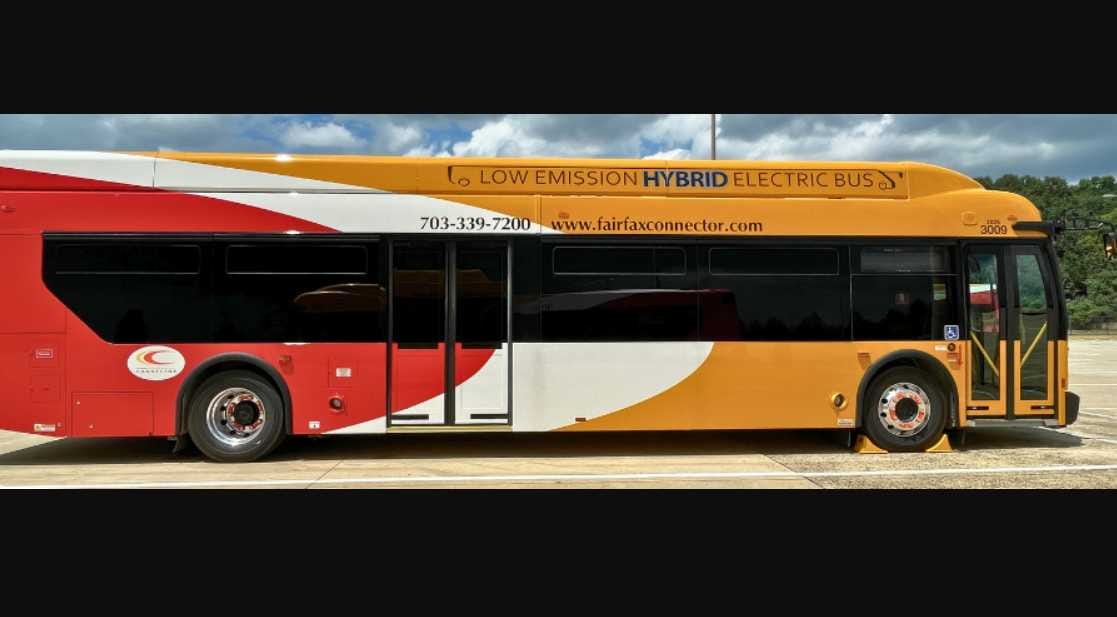 A hybrid-electric Fairfax Connector bus (courtesy Fairfax County Department of Transportation) | FFXnow Low-emission hybrid electric bus in red, white, and orange parked in a lot, with 'Low Emission Hybrid Electric Bus' text on top.