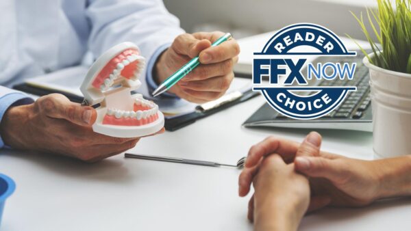 Dentist shows a dental model to a patient, pointing with a pen as a 'Reader FFX Now Choice' logo appears on the right.