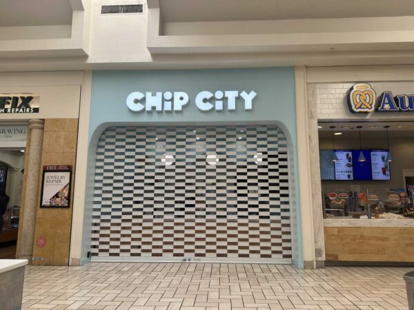 Closed Chip City storefront with a light blue facade and striped security shutter in a mall corridor