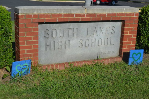A concrete sign that reads "South Lakes High School" surrounded by brick casing.