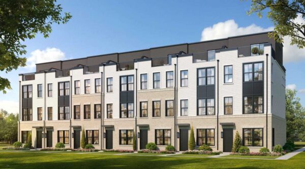 Row of modern townhomes with light brick, white siding, black-framed windows, and small front yards.
