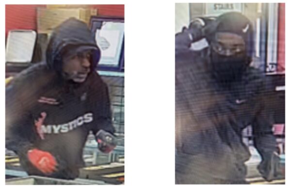 Surveillance image of a person in a dark hoodie and face covering at a store checkout, handling items at the counter.