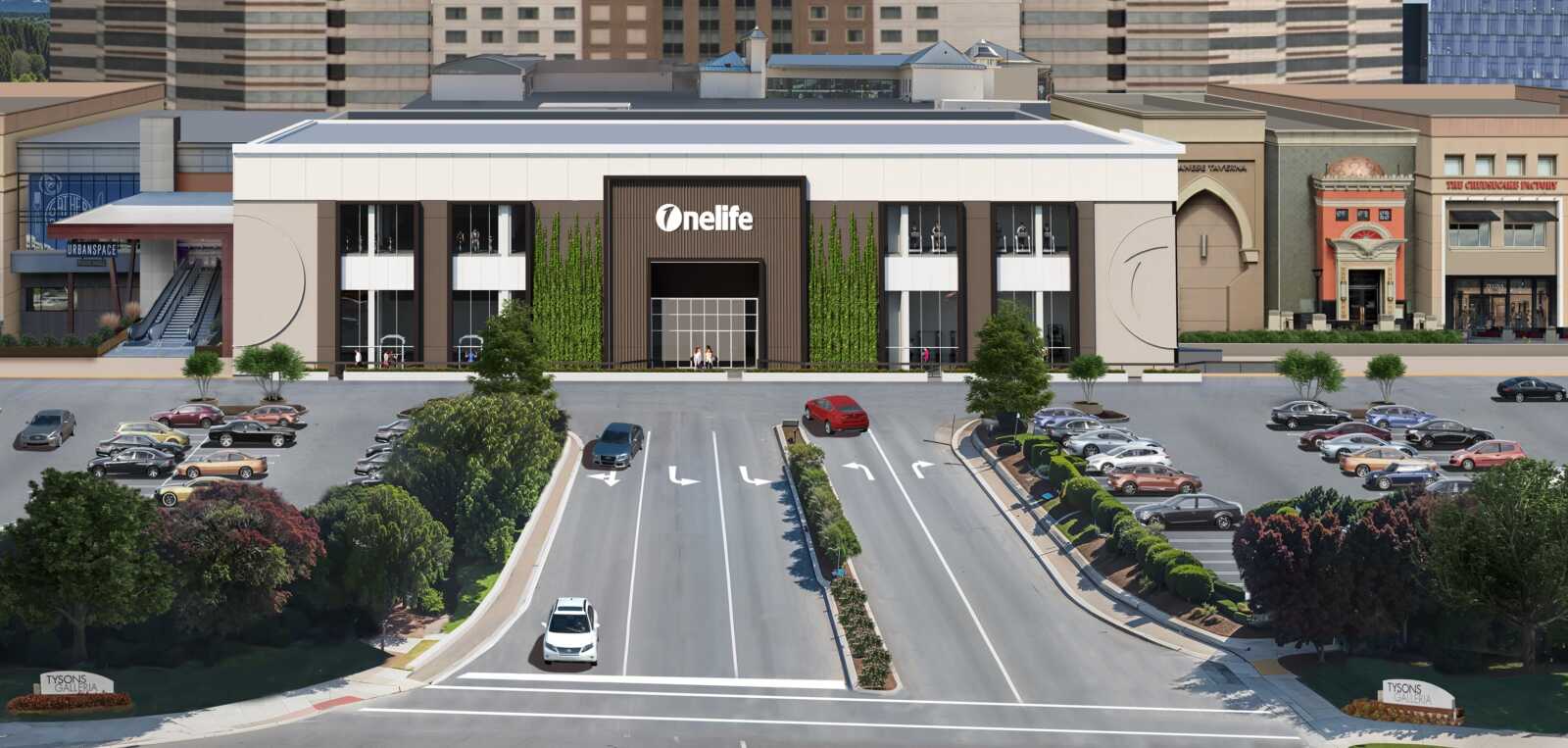 Rendering of the future Onelife Tysons club at Tysons Galleria (courtesy Onelife Fitness) | FFXnow Wide view of a modern shopping center with a prominent 'OneLife' sign, glass windows, and a busy parking lot at the front.