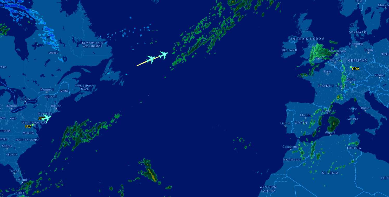 Final A340-600 flight leaves the U.S. East Coast, trailing two other Lufthansa A340-600s across the Atlantic on Oct. 18 (screenshot via Flight Aware) | FFXnow Live flight map showing airplanes over the Atlantic between North America and Europe, with airport labels like JFK, IAD, and FRA nearby on the coastlines.