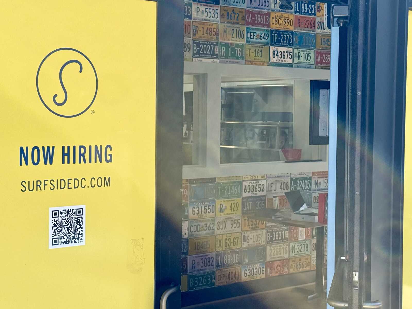 Bright yellow panel advertising Now Hiring with a QR code and Surfside DC website link, left side of the image