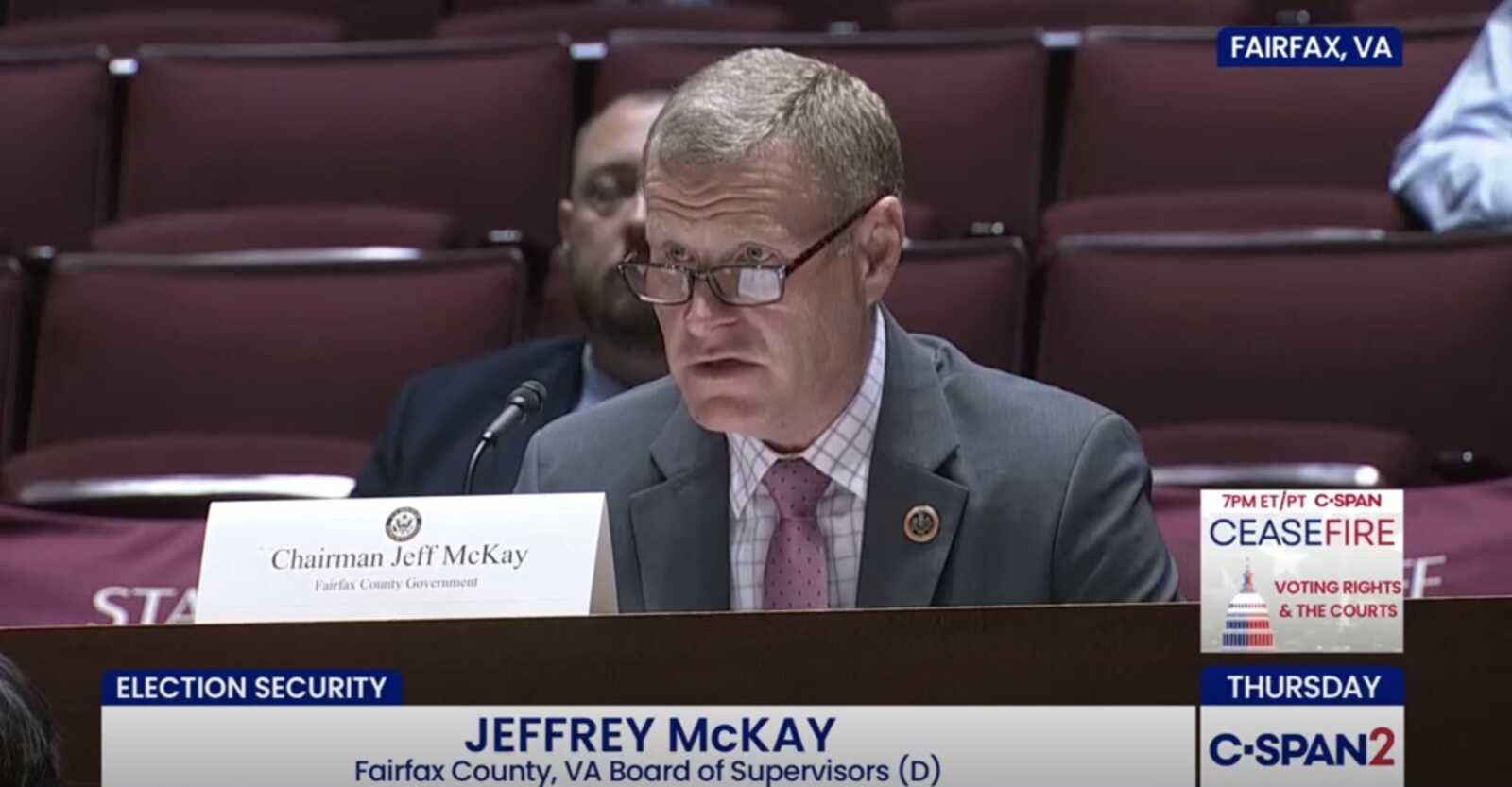 Fairfax County Board of Supervisors Jeff McKay speaks at a congressional forum at the Fairfax County Government Center (Screenshot via CSPAN) | FFXnow Jeffrey McKay, Fairfax County Board of Supervisors chair, speaking at a hearing; nameplate reads'Chairman Jeff McKay' with a microphone in front.